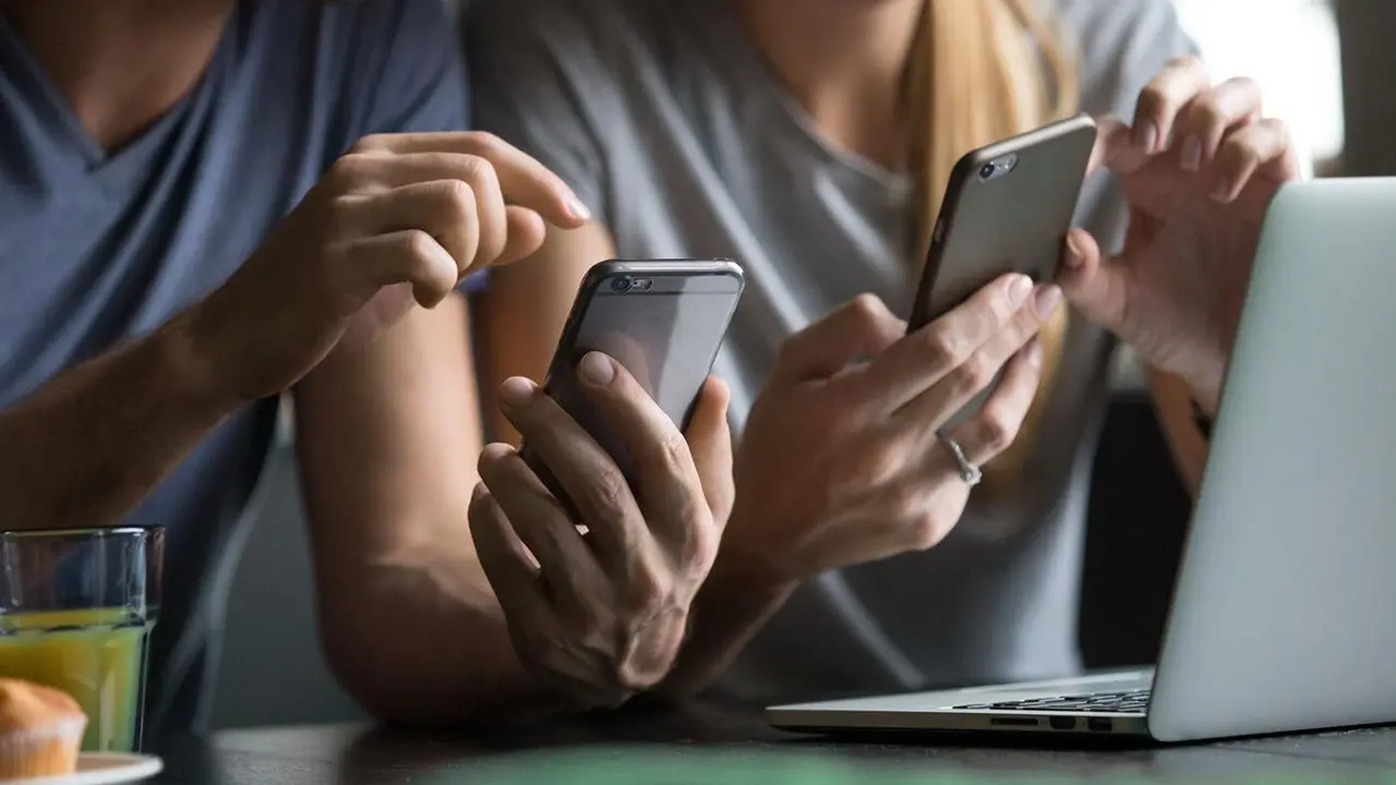 Jóvenes haciendo uso de sus teléfonos móviles. UVIGO
