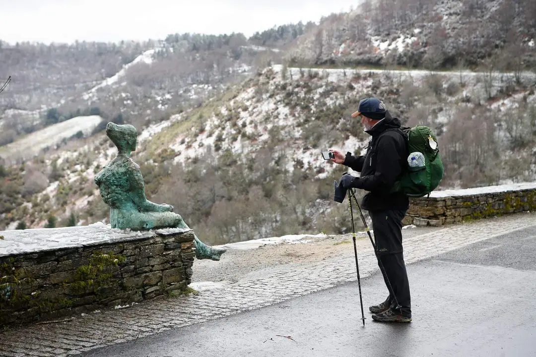 Un peregrino fotografía la nieve en Piedrafita. CARLOS CASTRO