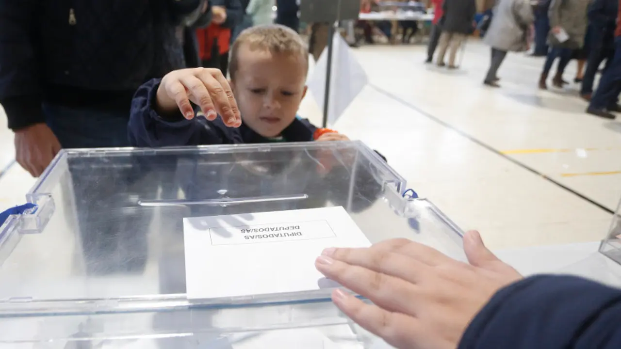 Un niño deposita el voto de un familiar, este domingo. JAVIER CERVERA-MERCADILLO