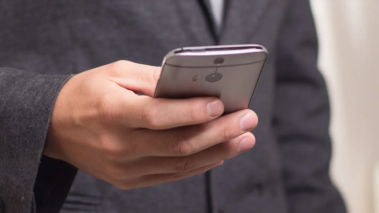 Una persona consultando su teléfono móvil. PIXABAY