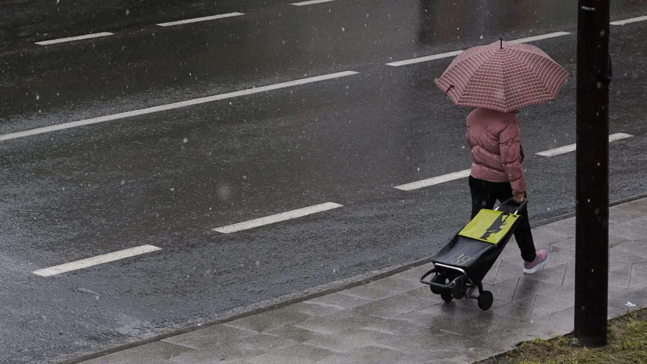 Unha muller camiña por Palas de Rei nun día de choiva.  EFE Eliseo Trigo