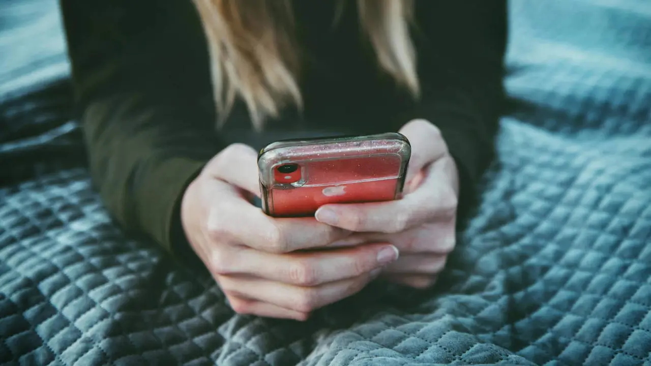Una joven con un teléfono móvil. PEXELS