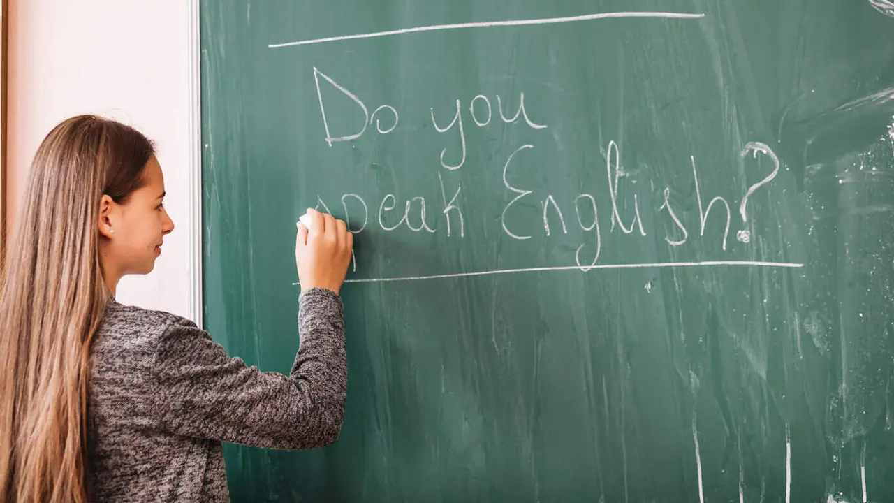 Una mujer escribe en una pizarra. FREEPIK