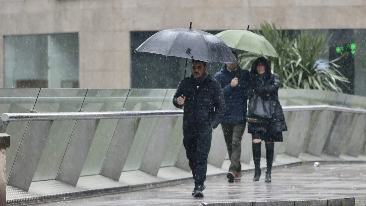 Personas con paraguas en Pontevedra, este domingo. RAFA FARIÑA