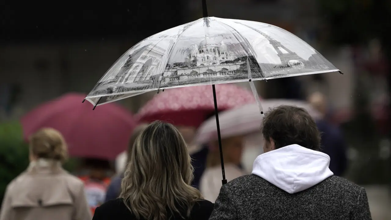 Dos personas se protegen de la lluvia en Oviedo este Viernes Santo. PACO PAREDES