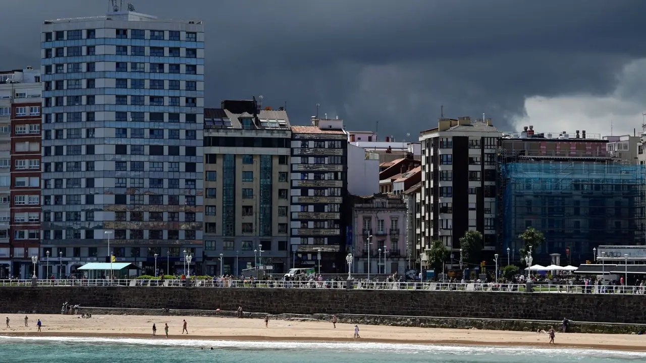 Vista de la playa de San Lorenzo, en Gijón, con nubes de tormenta al fondo. EFE