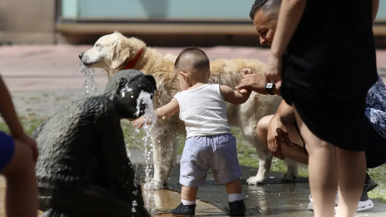 Una familia refrescándose en una fuente en Pontevedra. JAVIER CERVERA-MERCADILLO