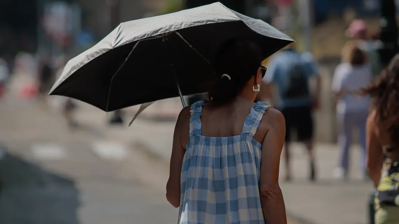 Una mujer se protege del sol con una sombrilla en Vigo. ADRIÁN IRAGO