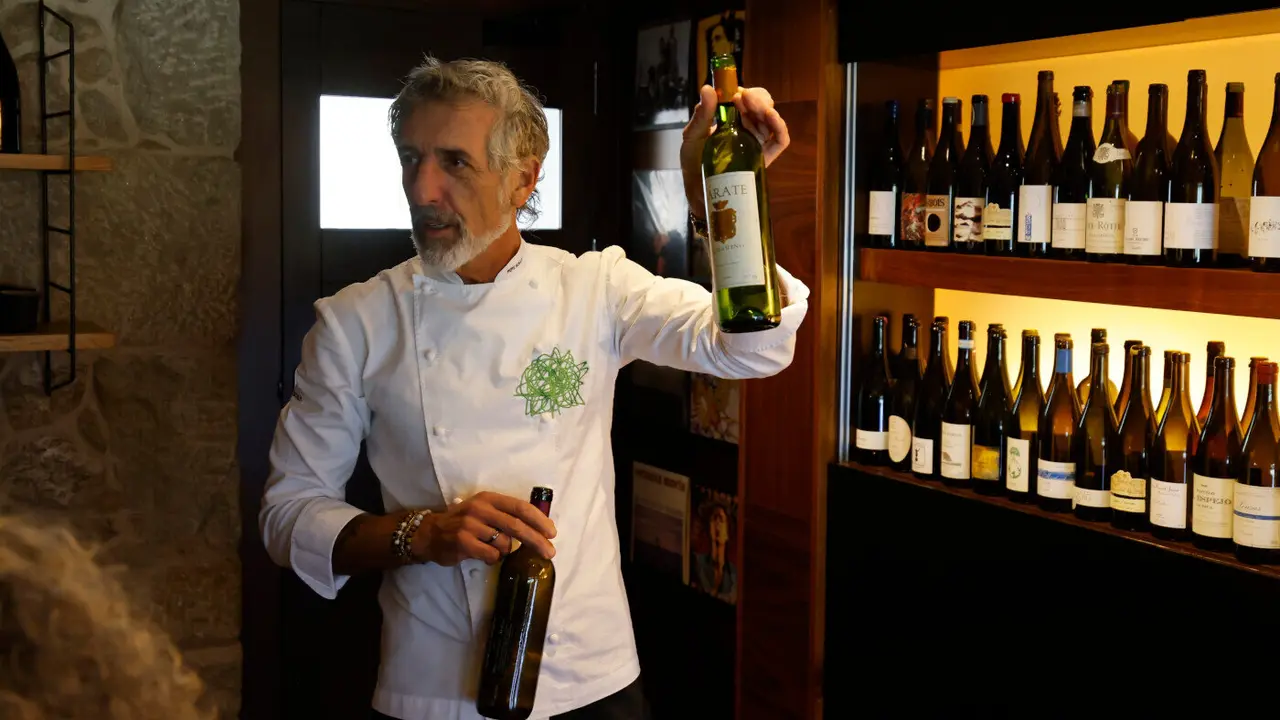 El cocinero Pepe Solla mostrando las botellas de La Taberna. GONZALO GARCÍA