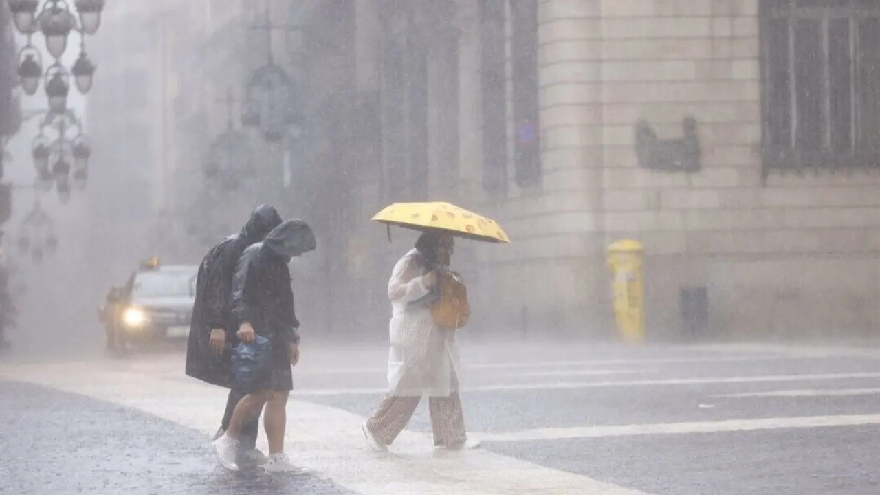 Varias personas se resguardan de la lluvia en Barcelona. QUIQUE GARCÍA (EFE)