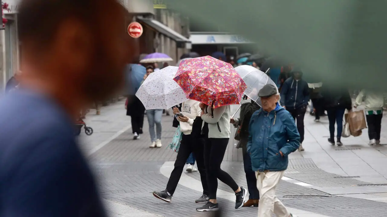 Gente con paraguas en Pontevedra este lunes. DAVID FREIRE