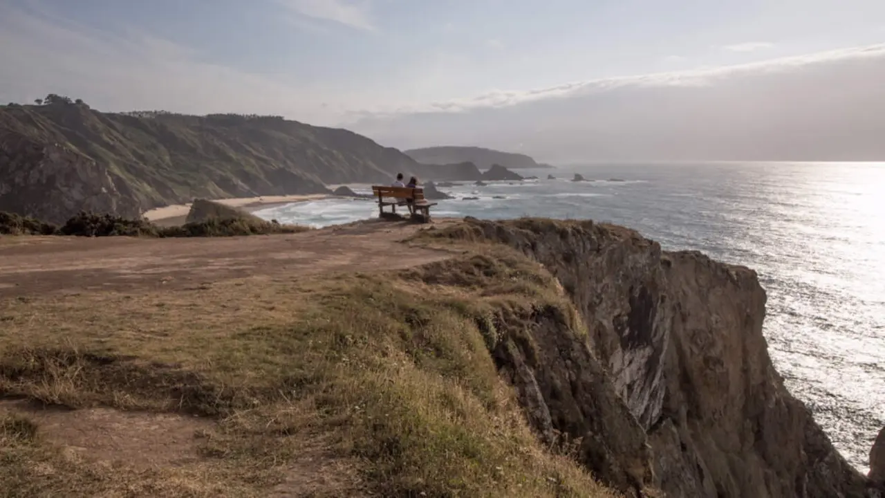Dos personas sentadas en el banco de Loiba, en Ortigueira. XUNTA