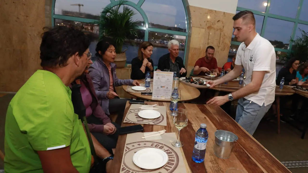 Peregrinos disfrutando de la Mesa do Camiño en la Praza de Abastos. DAVID FREIRE
