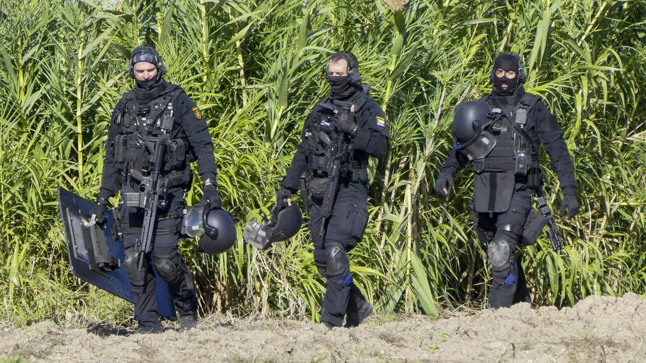Agentes de policía desplegados frente a la nave en la que se produjo el tiroteo en Isla Mayor. EFE