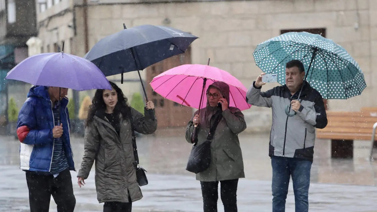 Cuatro personas paseando por Pontevedra durante el paso de la borrasca Claudia. JAVIER CERVERA-MERCADILLO