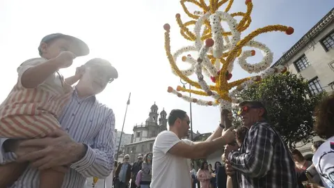 Á esquerda, José María Domínguez co seu neto no colo, arrodeado de veciños, nunha Festa dos Maios na Ferrería. DAVID FREIRE/ARQUIVO